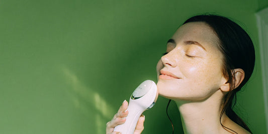 Woman using red light therapy device.