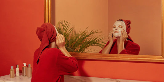 Woman applying a natural face mask for skin tightening at home.
